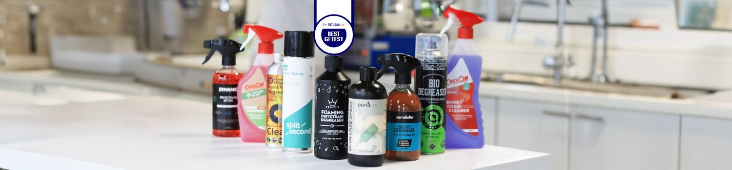 A collection of various bike cleaning products displayed on a countertop, featuring brands like Cyclon and Muc-Off.
