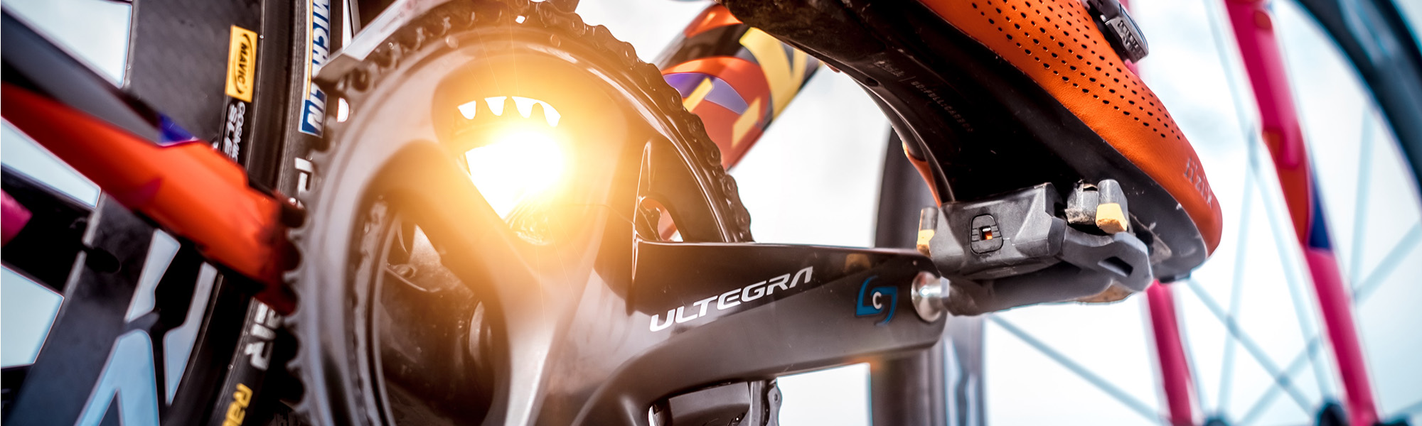 Close-up of an Ultegra crankset with an orange cycling shoe clipped in.