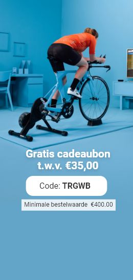 A cyclist in an orange shirt rides an indoor trainer in a blue room. The image includes a promo code for a gift voucher.